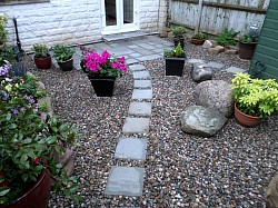 paths and patio bedded on 4 inch granite concrete with 45 degree edges hidden under pebbles