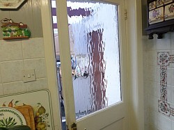 Door glass replaced with tempered glass after previous untempered glass shattered in wind